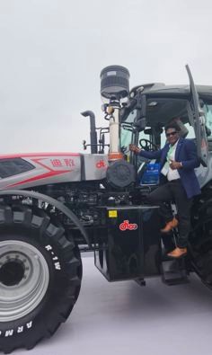 KCCIMA delegate climbing into the cab of a silver tractor, giving a thumbs up